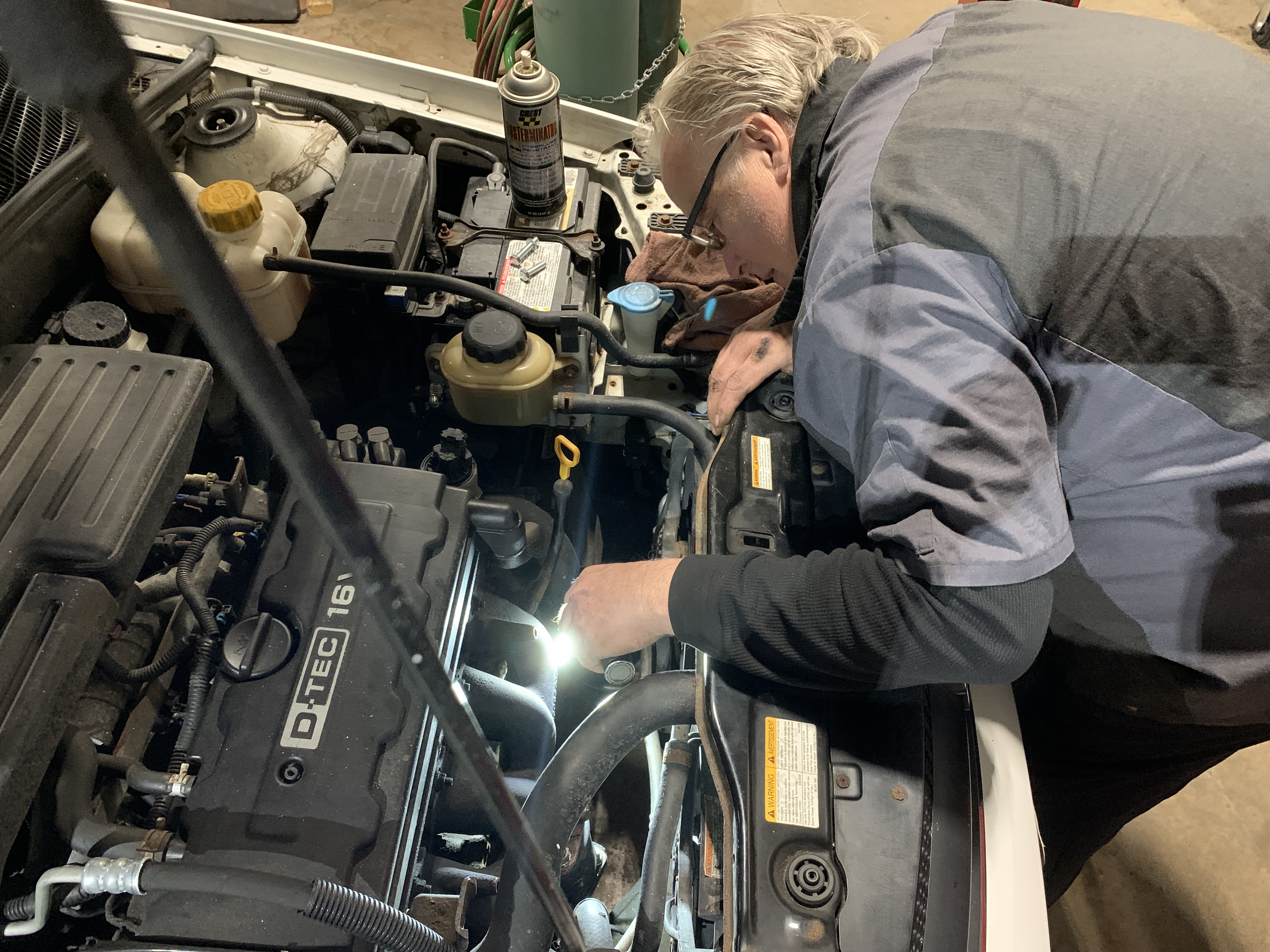 Auto Tech Looking at Engine Part | Lou's Car Care Center, Inc.